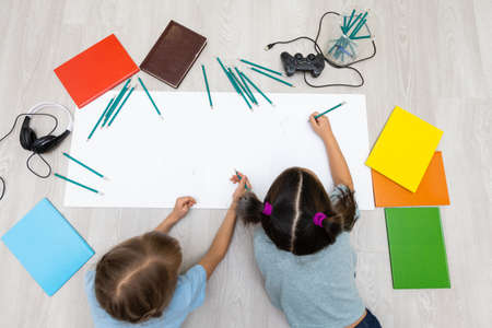 two little girls learn while lying on the floor. Educationの写真素材