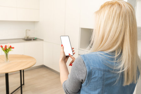Woman using smartohone in smart house, empty screenの写真素材