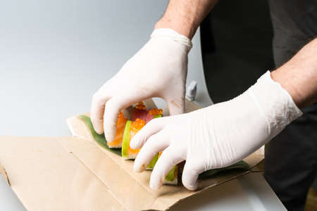 Cook hands making japanese sushi roll. Japanese chef at work preparing delicious sushi roll with eel and avocado. Appetizing japanese food.の写真素材