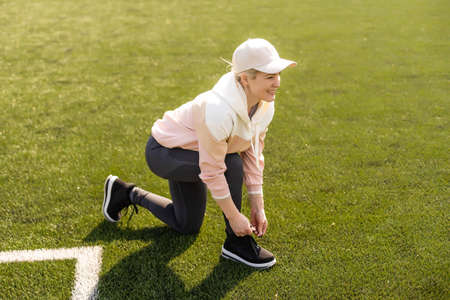 sexy fitness woman in sportswear. athletic lady warming up on stadium running track. female athlete do sport workout. trainer or coach training. perfect body shape. healthy and sportyの写真素材