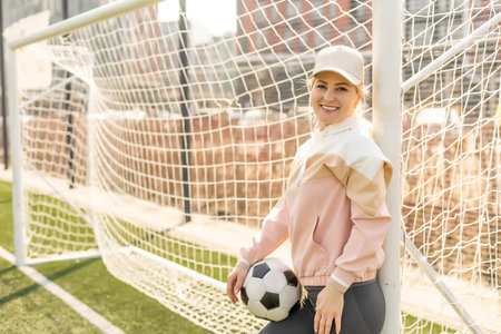 Pretty womens soccer. Young woman in sportswear with a soccer ball on the grassの写真素材