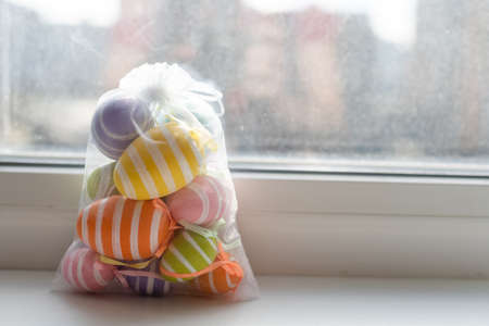 Creatively Easter painted eggs in a bag on a white background. Flat lay, copy space.の写真素材