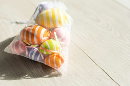 multi-colored chicken eggs in bag mesh on white background. easterの写真素材