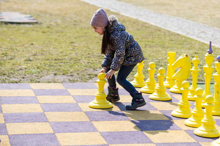 little girl playing big chessの写真素材