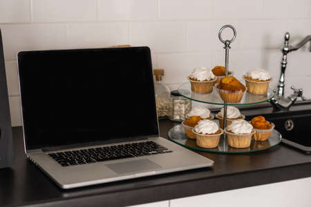Laptop white screen on table with kitchen background.の写真素材