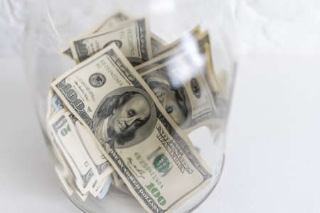 One hundred dollar bills in a glass jarの写真素材