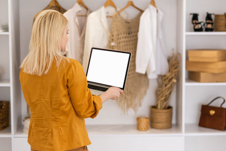Rear view of business woman hands busy using laptop at office desk, with copyspace