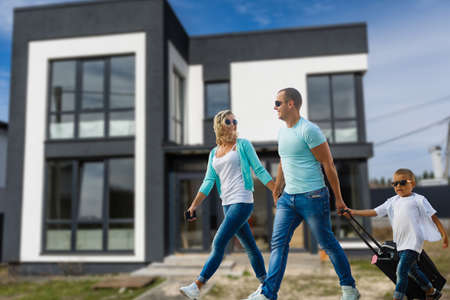 Happy family near new house. Real estate concept.の写真素材