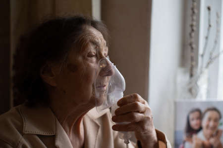 close-up portrait of an elderly woman making inhalationの写真素材