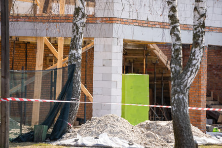 Facade of building made from white blocks with big windows under construction works