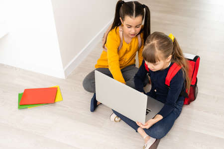 Portrait of two girls studying in front of laptopの写真素材