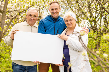 family holds holds photo canvas in the garden