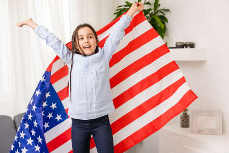 Portrait of a little girl with the flag of America. American education, study in Americaの写真素材