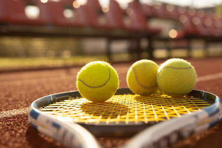 A tennis racket and new tennis ball on a freshly painted tennis courtの写真素材