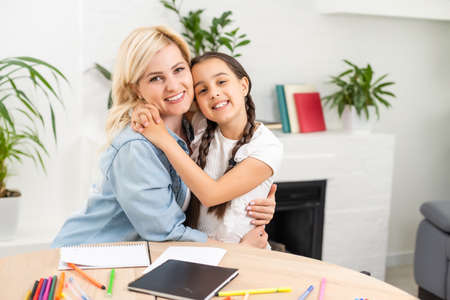 A mother helping her daughter with homeworkの写真素材