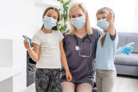 female doctor or pediatrician with stethoscope with two little girls patient . kid girl on medical examination checkupの写真素材