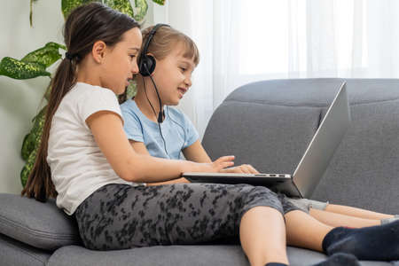 Cute children doing homework with laptopの写真素材