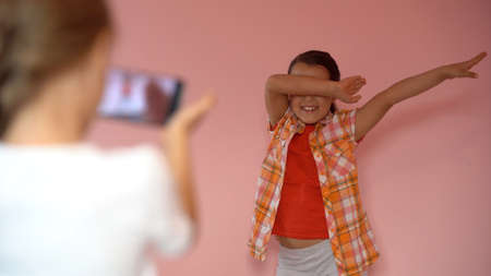 two little girls taking photo with a smartphoneの写真素材