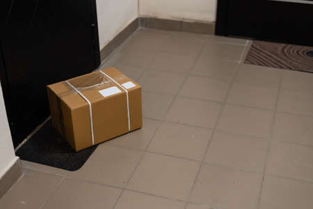 Cardboard box on rug near entrance doorの写真素材