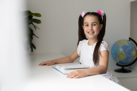 education and school concept - little student girl studying and reading book at school.