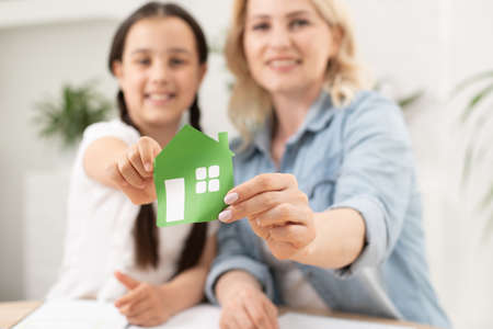 Mother holding hands with child and illustration of houseの写真素材