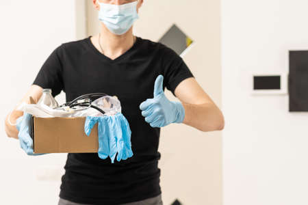 Delivery of medical equipment to the hospital. People in protective suits hand over boxes.の写真素材