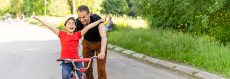 loving father teaching daughter to ride bikeの写真素材