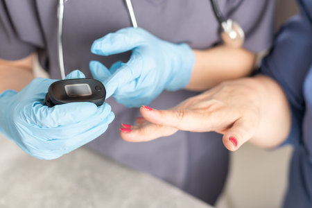 Nurse uses pulse oximeter to measure elderly patients blood oxygen saturation