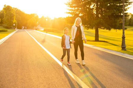 mother accompanies the child to school. mom supports and motivates the student. the little girl does not want to leave her mother. fears primary school. communication problems. attachment to parentsの写真素材