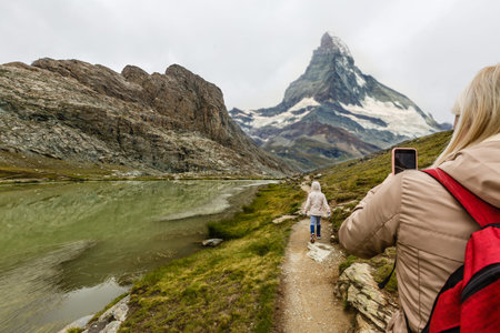 Rear view of a woman with backpack looking at the view Female hiker relaxing on mountain top.