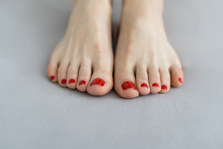 Woman legs on the bed with white bed clothesの写真素材