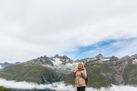 Woman on mountain top of mountain landscape around lake and blue sky.の写真素材