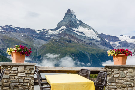 beautiful view of restaurant surround by mist lake and mountains with empty tableの写真素材