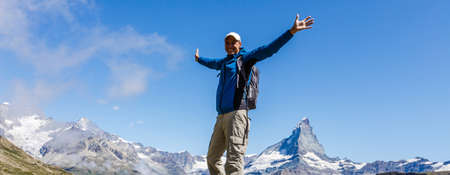 elderly man with a backpack goes on the road to the mountainsの写真素材