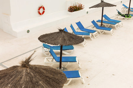Hotel swimming pool with empty sun loungers