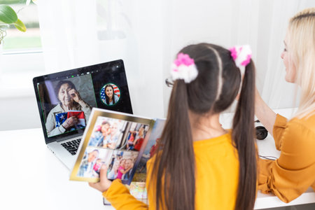 Mom and daughter watch family photo album.の写真素材