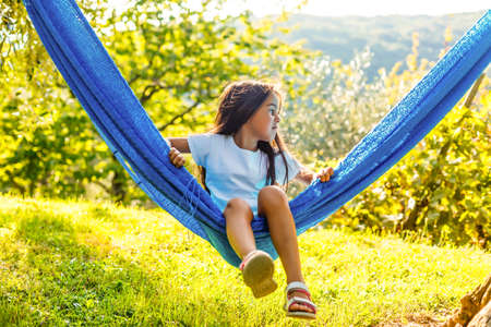 Adorable little girl on summer vacation relaxing in hammockの写真素材