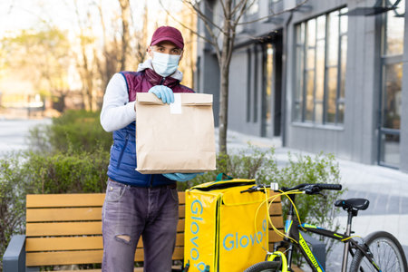 KIEV, UKRAINE - April 28, 2021: Glovo bike courier on the street. Delivery boy of Glovo delivery...