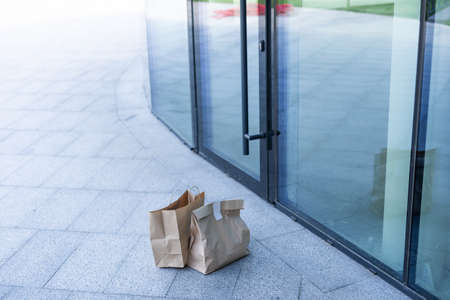 Paper bag near door of house. Safe delivery concept. Contactless home food delivery. Precautionary measures.の写真素材