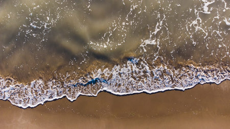 Aerial view of sandy beach and waves