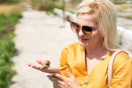 snail sitting on a womans handの写真素材