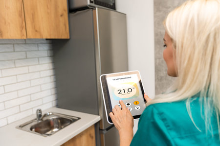 Rear view of young woman making setting of her home with online smart home application