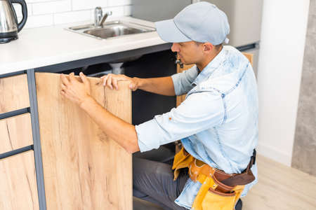 Craftsman carpenter at kitchen cabinet installation service workの写真素材