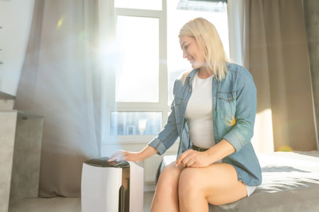 attractive woman with air purifier in the modern home.の写真素材