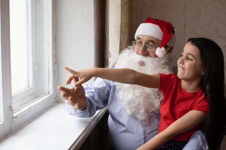 an elderly man in a santa hat and a granddaughterの写真素材