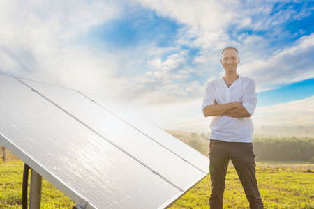 oung engineer is checking an operation of sun and cleanliness of photovoltaic solar panels on a sunset. Concept: renewable energy, technology, electricity, service, green, futureの写真素材
