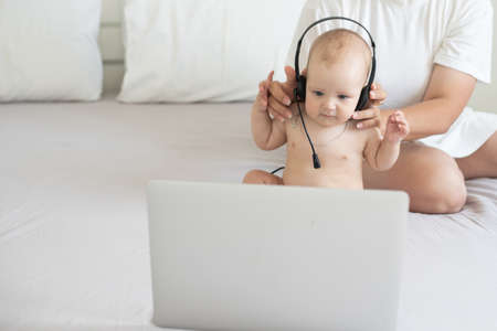 Mom and baby with laptop computer working from homeの写真素材