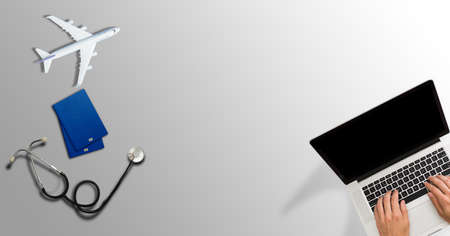 image of medical stethoscope, passport book and laptop computer.Trip and Travel insurance conceptの写真素材