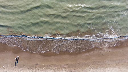 Top view of texture waves sandy beach.