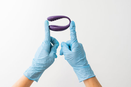 sex toy for adults in gloved hand isolated on white